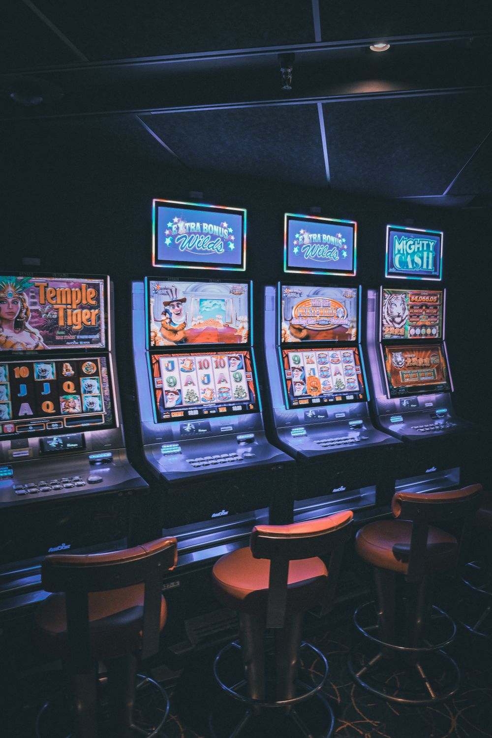 Deretan mesin slot bercahaya di lantai kasino, ilustrasi kategori permainan slot